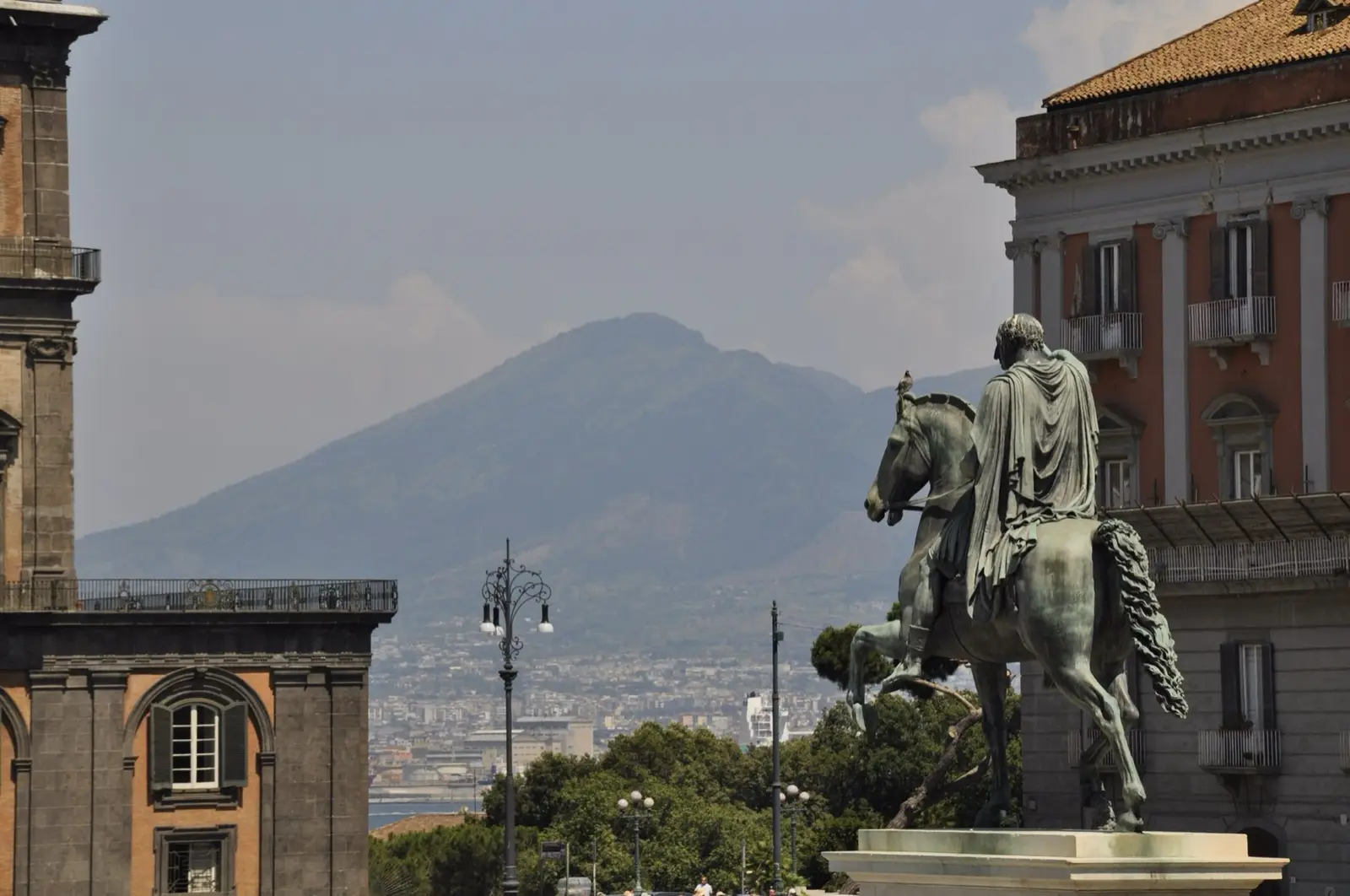 An equestrian statue in Piazza del Plebiscito with Vesuvius behind