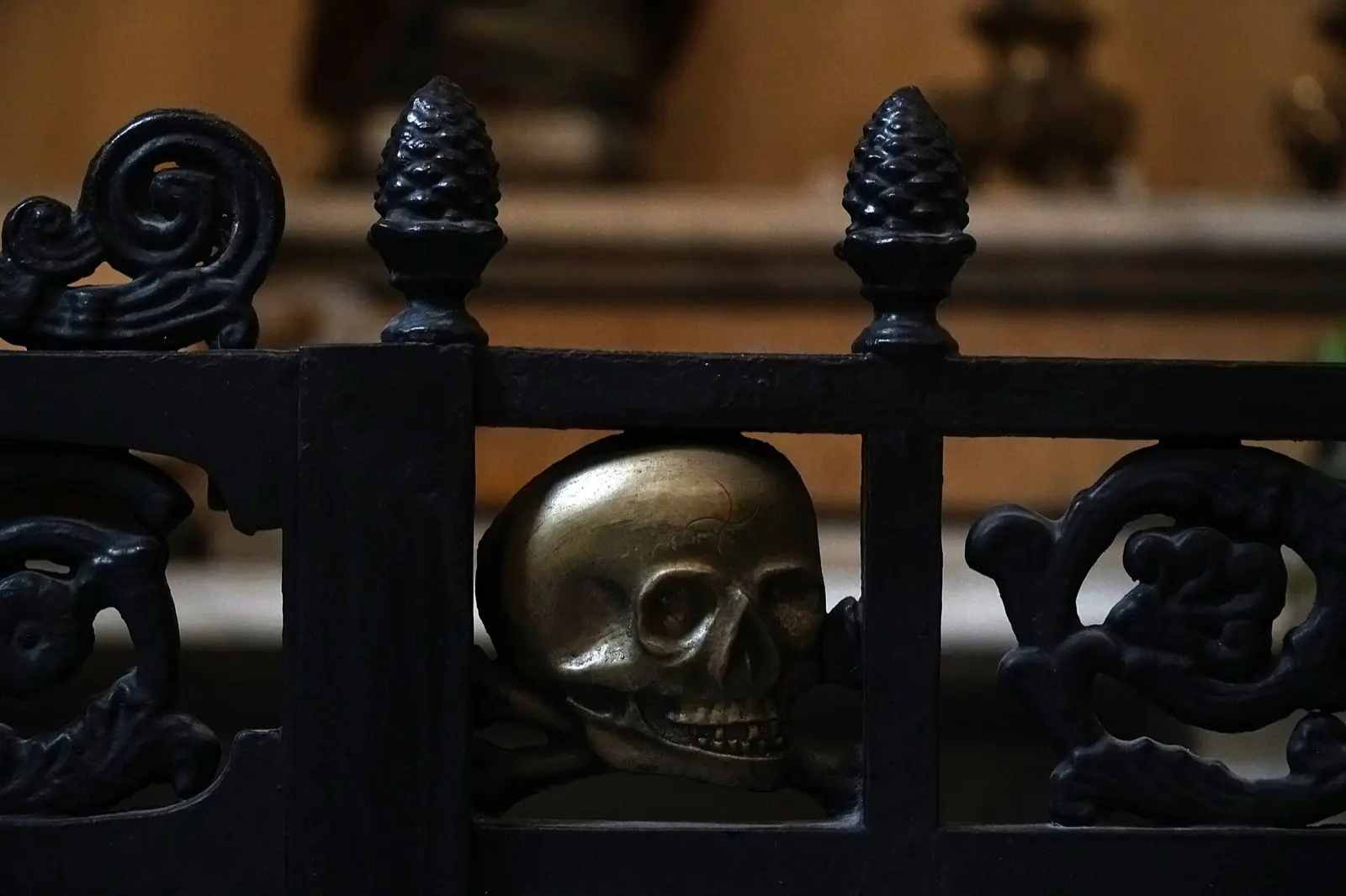 A bronze skull set into an ornate iron railing inside the church of Purgatorio ad Arco