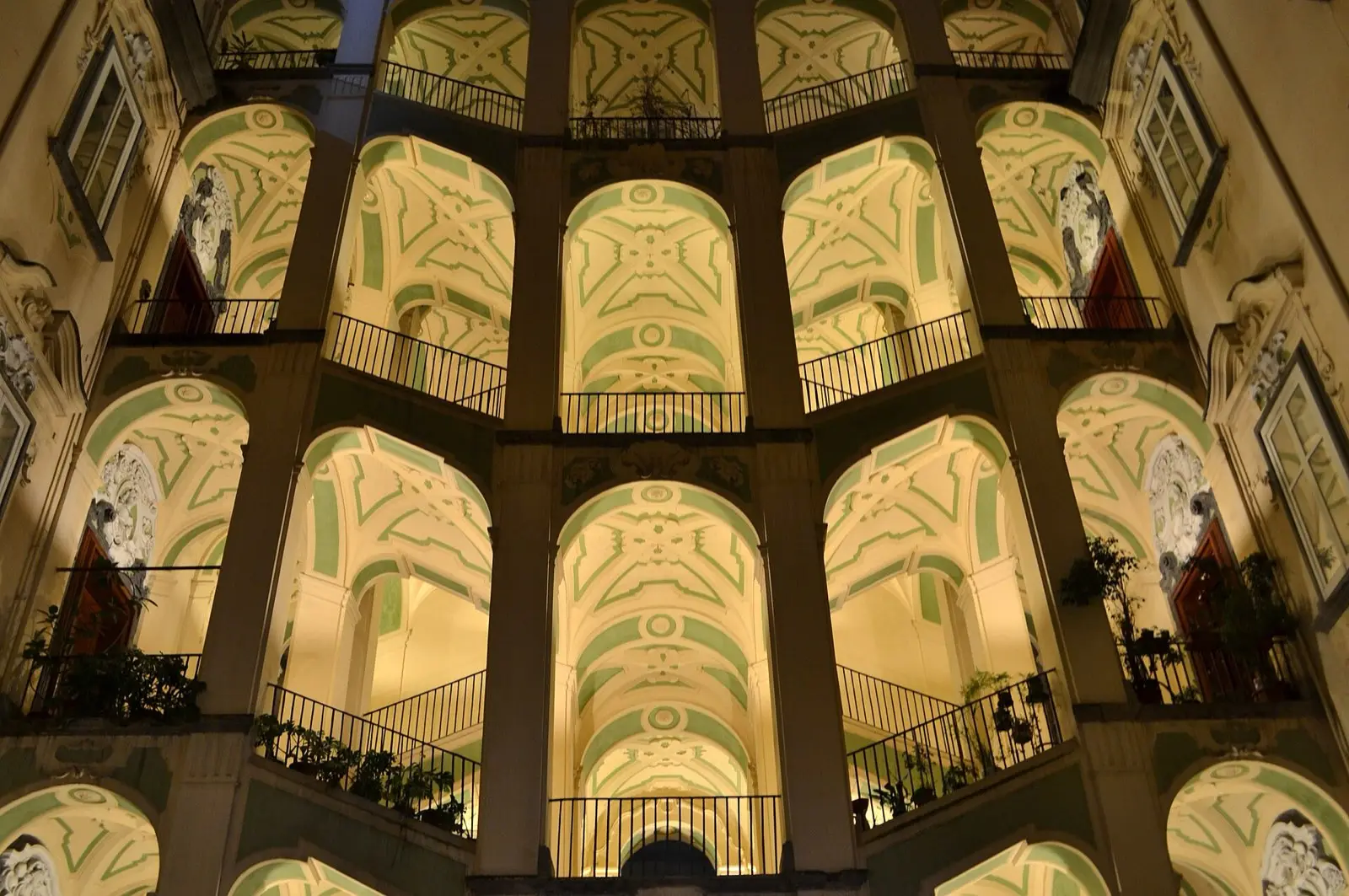 The open arched staircase of Palazzo dello Spagnolo, lit at dusk