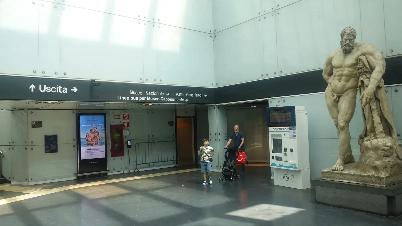 A large statue of Hercules leaning on his club in the hall of Museo station