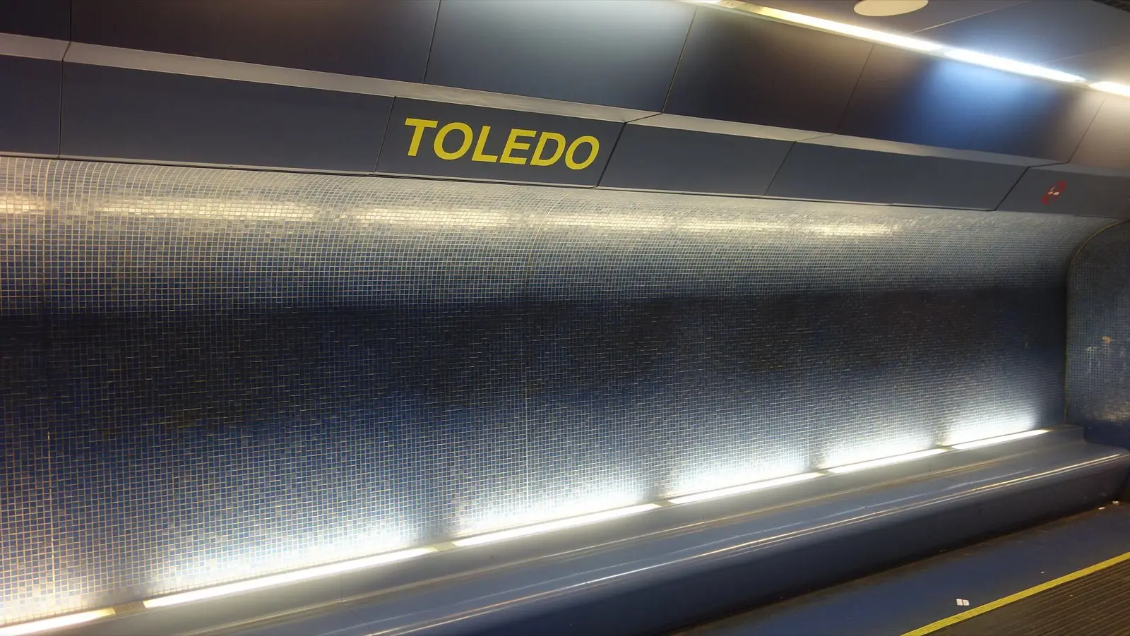 The shimmering blue mosaic wall of Toledo metro station platform